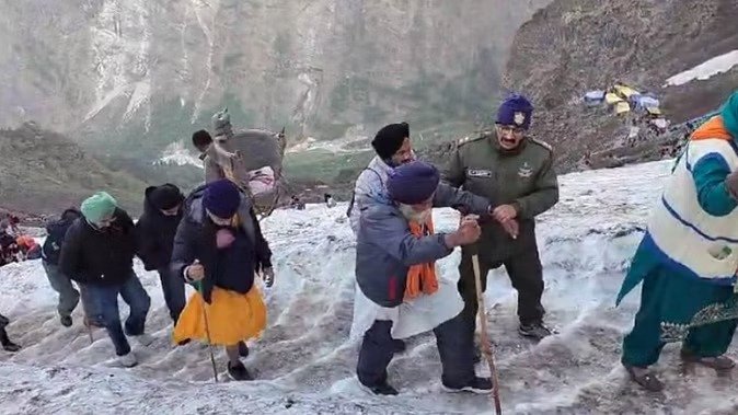 बर्फीले फिसलन भरे रास्ते पर हाथ पकड़कर आगे बढ़ रहे श्रद्धालु बर्फीले फिसलन भरे रास्ते पर हाथ पकड़कर आगे बढ़ रहे श्रद्धालु